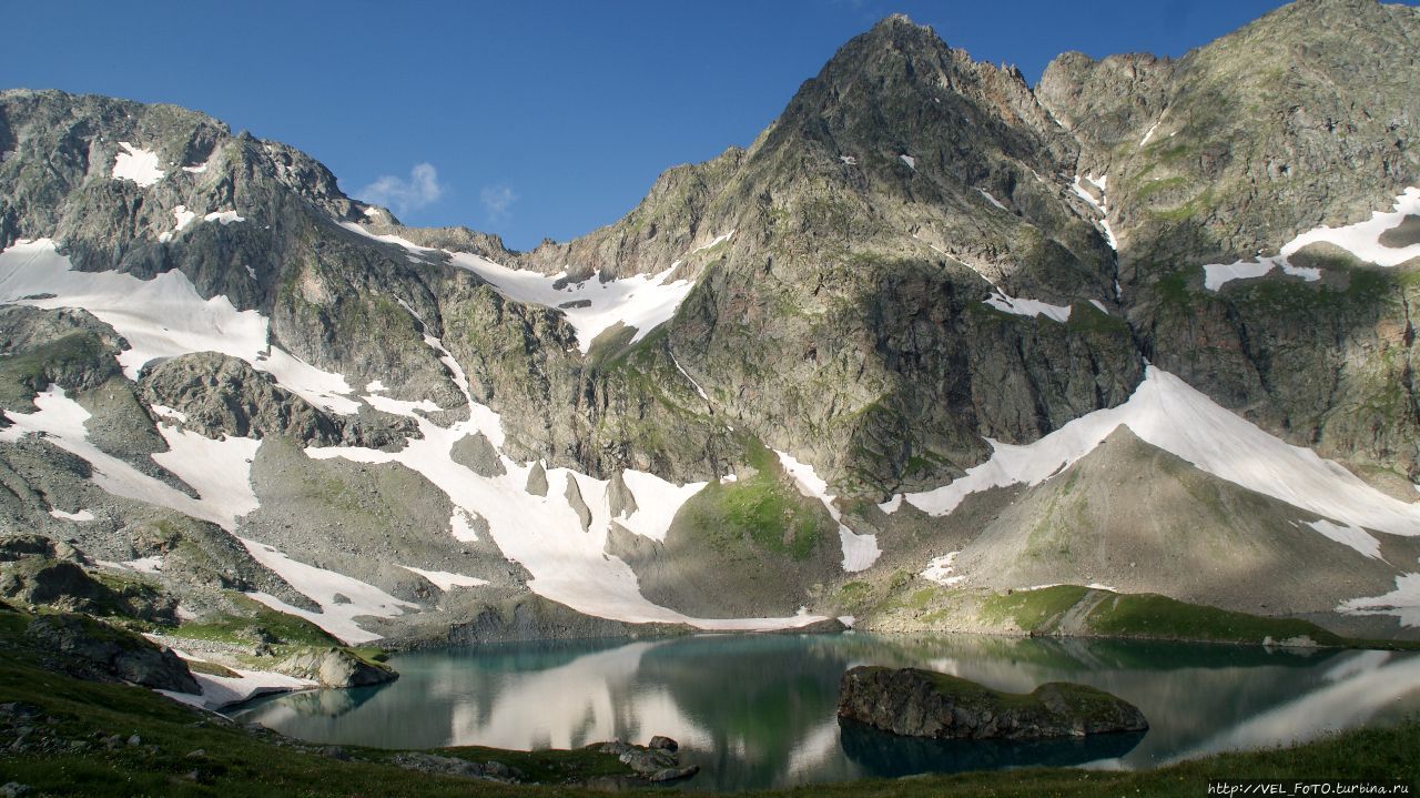 ОЗЕРО БЕЗМОЛВИЯ(Большое Имеретинское озеро) — самое большое каровое озеро (площадь 0,21км2, максимальная глубина 18м) не только в рассматриваемом районе, но и на всем Западном Кавказе (в пределах Краснодарского края).
С высоты обрамляющих его горных вершин, оно напоминает грушу (основной бассейн) с карстом-заливом (аппендиксом), соединяющимся с ним узкой горловиной. В акватории водоема в 8-10-ти м от его правого берега над прозрачной и почти невесомой голубизной — небольшой скалистый остров. Карачаево-Черкесская Республика, Россия