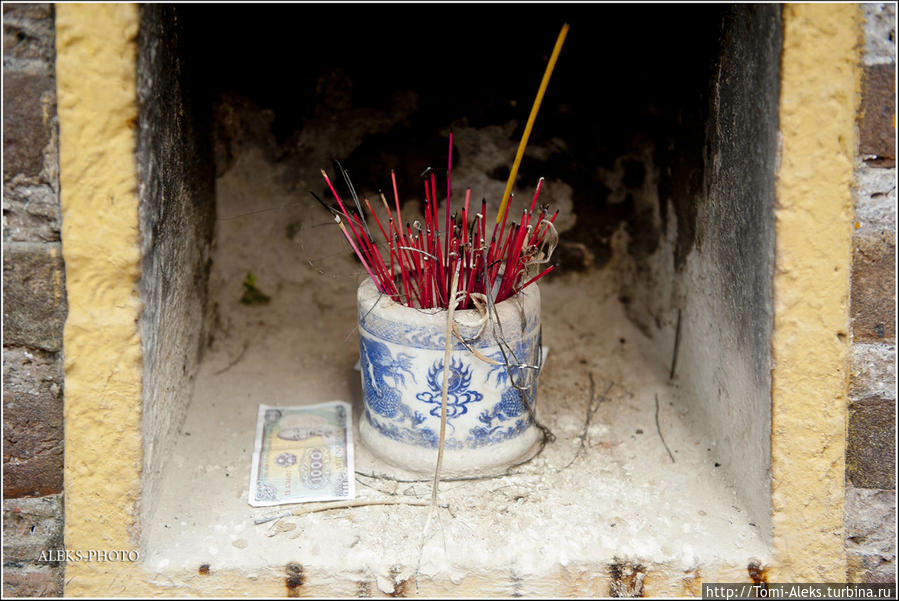 Как и пекинцы, ханойцы любят зажигать вот такие дымящиеся палочки. Еще у них принято класть богам деньги. Но с этим связан не совсем понятный ритуал... Ханой, Вьетнам