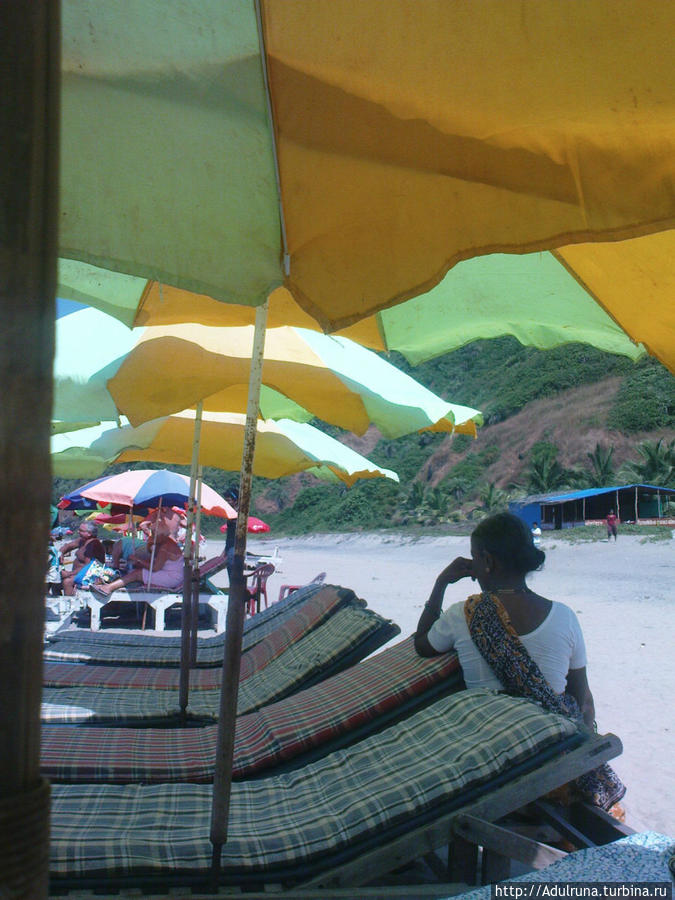 Женщина следит за лежаками... Место под зонтиком стоит 50 рупий....
