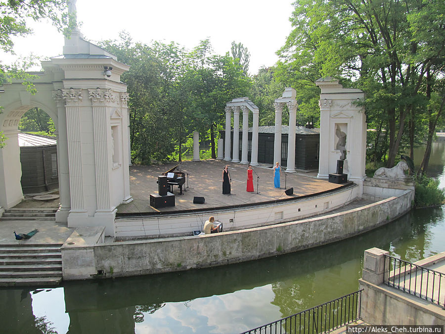 Рядом на берегу находится необычный амфитеатр — его сцена отделена водой от зрительских мест. Варшава, Польша