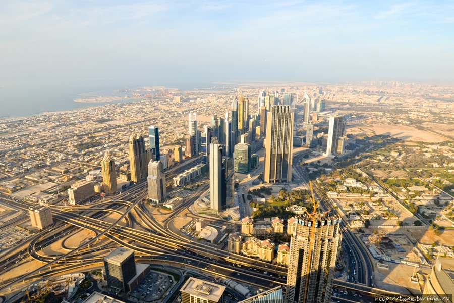 С высоты хорошо видно, как Дубай отвоевывает земли у пустыни, застраивая их высокими небоскребами. Дубай, ОАЭ