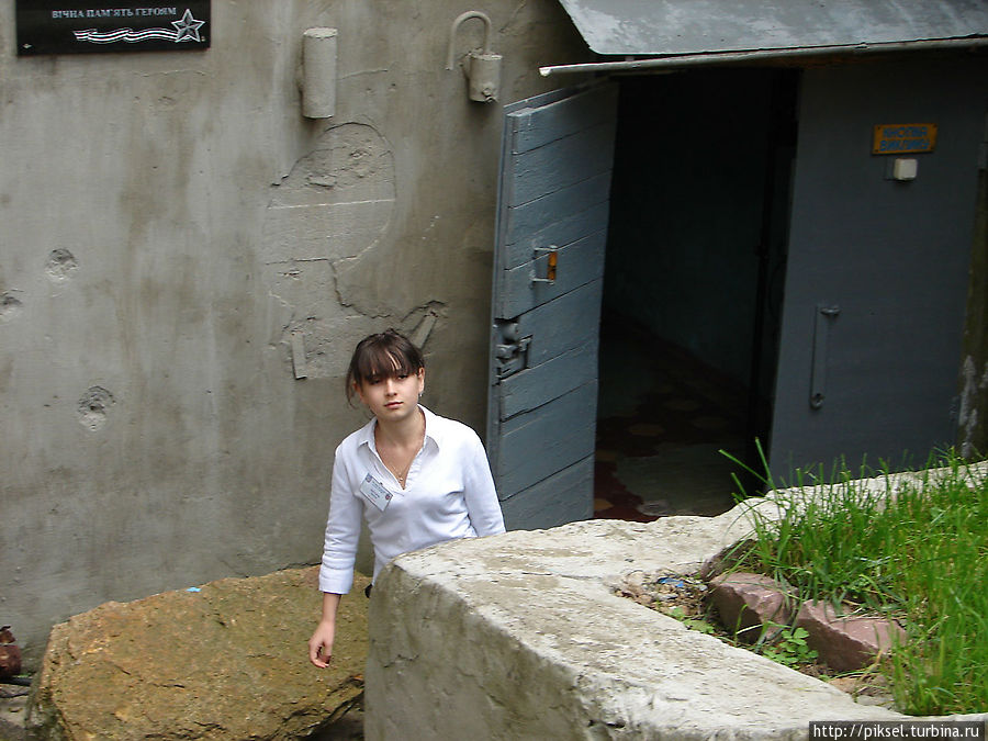 Вход в бункер. Молодая девушка — экскурсовод приглашает зайти в Бункер Коростень, Украина