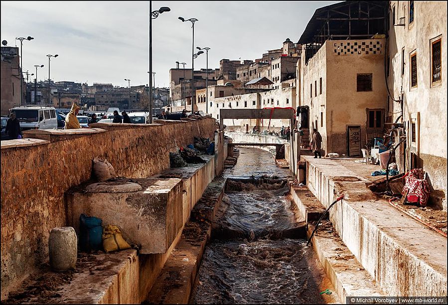 У стен кожевенного квартала, протекает речка, в которой рабочие поласкают шкуры перед обработкой. Фес, Марокко
