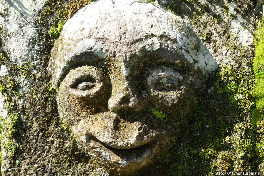 Лица,   высеченые   на   камнях   стены. Медан, Индонезия