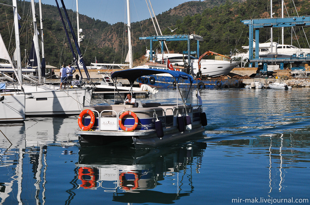 Отель расположен на самом берегу Эгейского моря, прямо у яхт клуба. Интересно расположение пляжа отеля под названием Secret Beach, на который гостей доставляют на небольшой моторной лодке. Турция