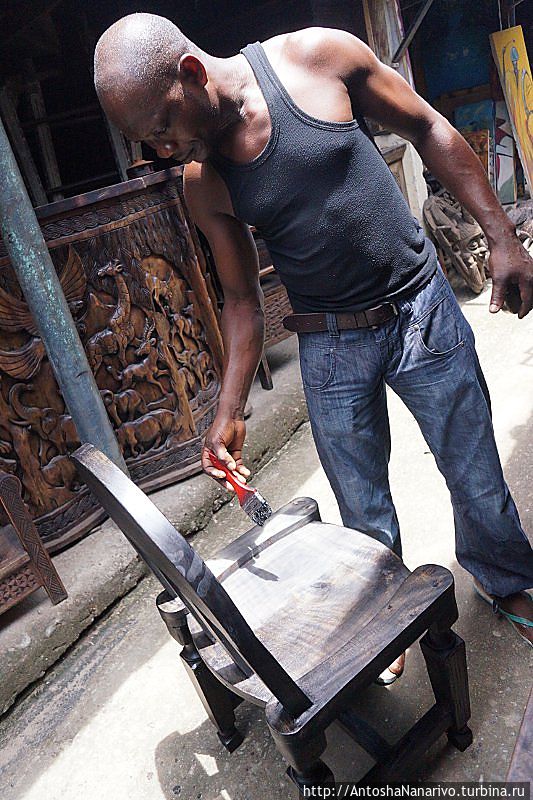 Мужик красит стул. Лагос, Нигерия