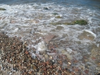 Камни попадаются на пляже как мелкие, так и покрупнее. Прибрежная полоса  песчаная и пологая.