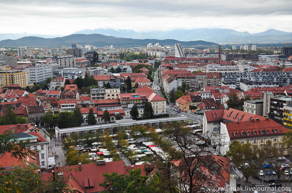Слой домов с черепичными крышами, слой современных построек, а дальше – потрясающей красоты горы, которые, своими верхушками, словно поддерживают небо от неминуемого падения на город. Любляна, Словения