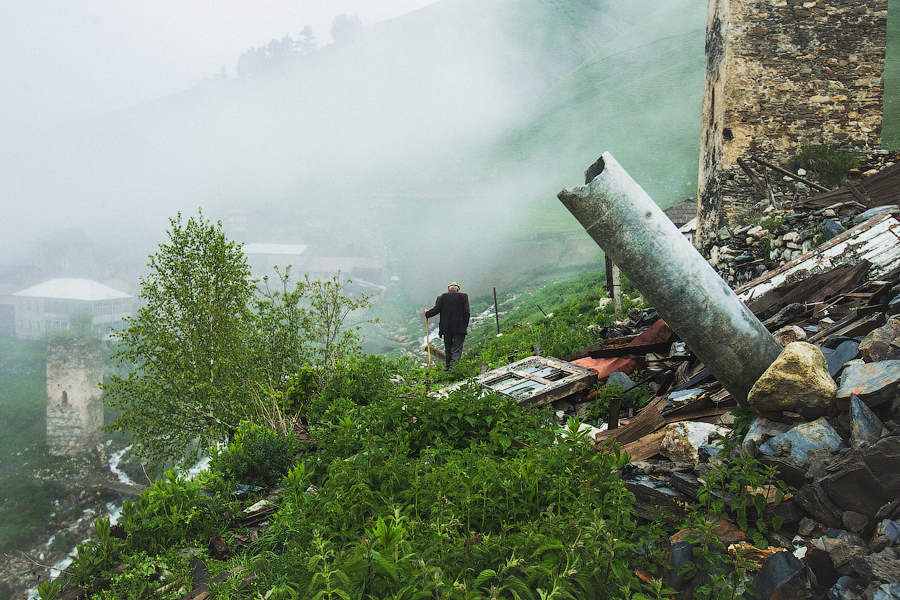 Дедушка отвел коров пастись и возвращается домой..