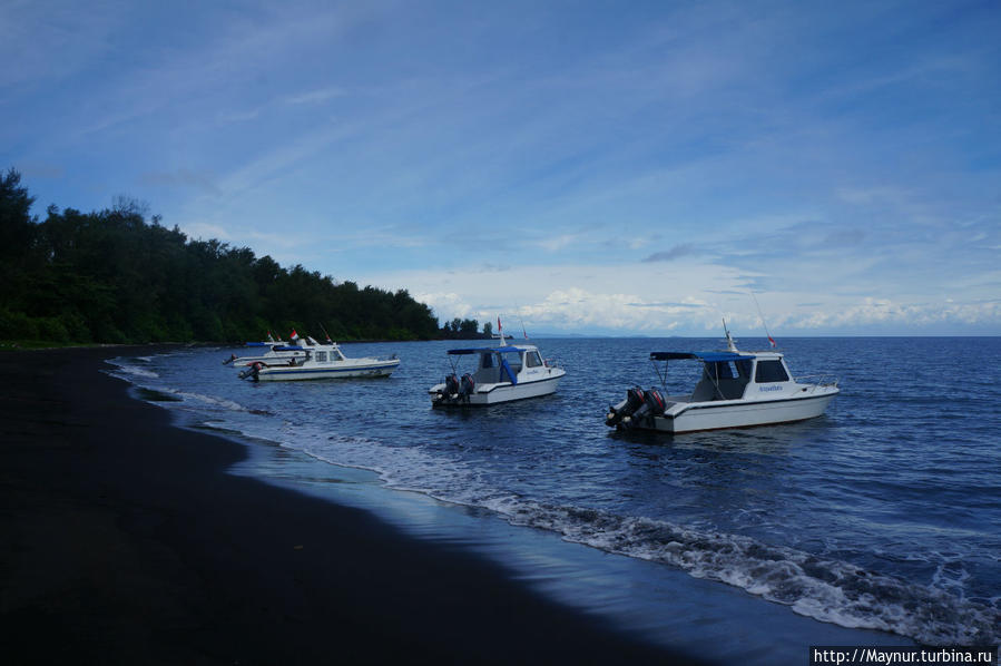 Синяя  вода   и    черный   песок   пляжа. Палембанг, Индонезия