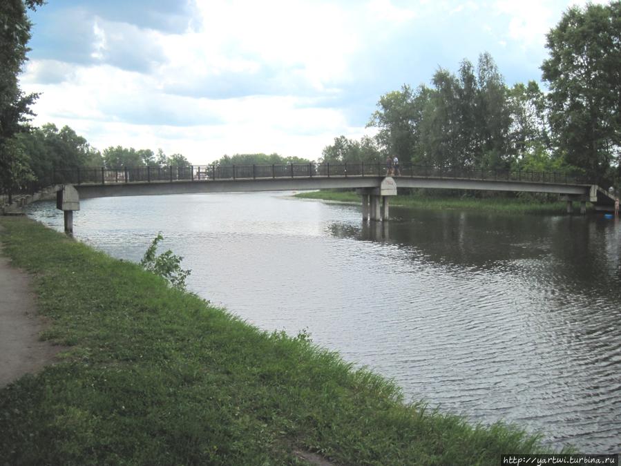 Река Цна с видом на пешеходный мостик к островам, где располагается городской парк Вышний Волочек, Россия