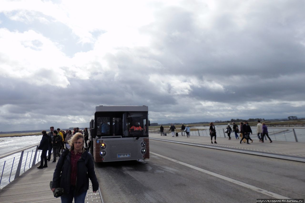 Автостоянка автобуса — шаттла Мон-Сен-Мишель, Франция Автостоянка автобуса — шаттла Мон-Сен-Мишель, Франция