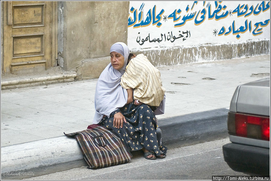 На улице Каира. Женщина держит на руках довольно большого мальчишку, может, он больной и она просит милостыню. Местное население, конечно, очень бедное...
* Каир, Египет