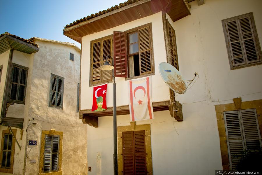 Патриотичные турки вывешивают на балконах флаги, с изображением отца турков. Никосия, Кипр