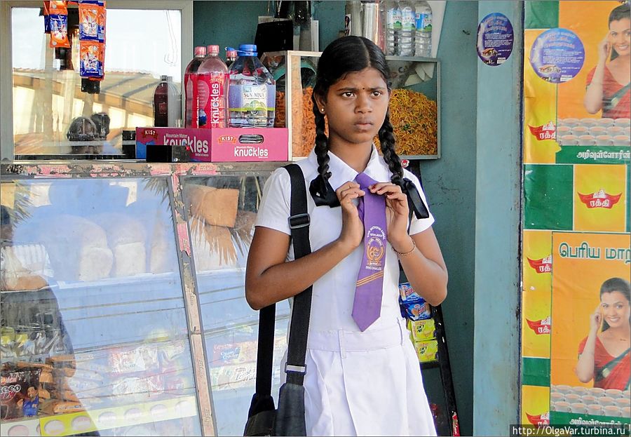 Эта девочка уже, как видно по галстуку, учится в другой школе нежели те, которых видела на пляже. Тоже о чем-то задумалась — идти домой или нет... Восточная провинция, Шри-Ланка