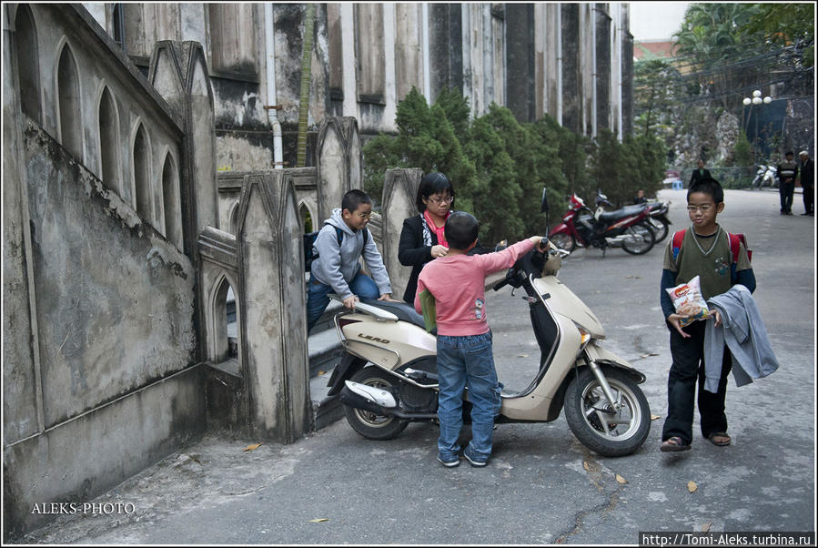 Семейство усаживается на мотоцикл после службы. В храме было довольно много детей... Ханой, Вьетнам