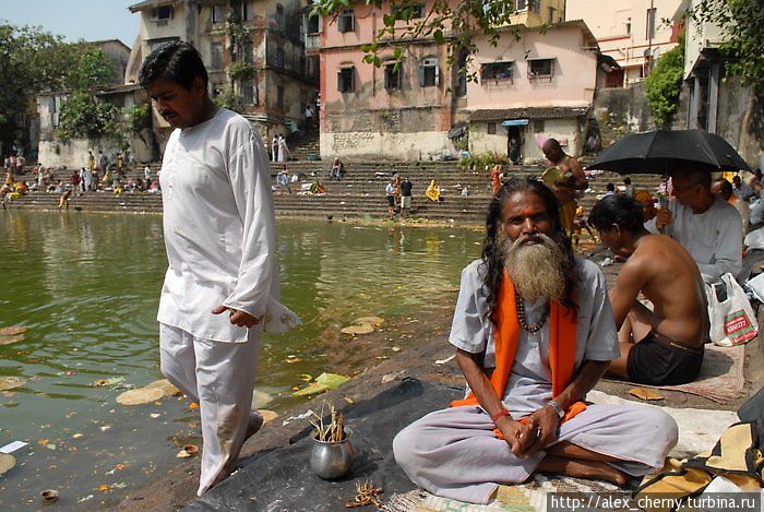 монах вяжет шерстяные нниточки на руки, всего-то несколько рупий Мумбаи, Индия