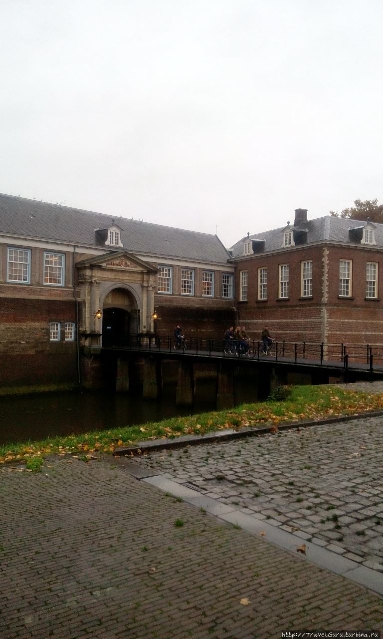 Ворота замка. из которых выезжают курсанты военной академии на... велосипедах. Бреда, Нидерланды