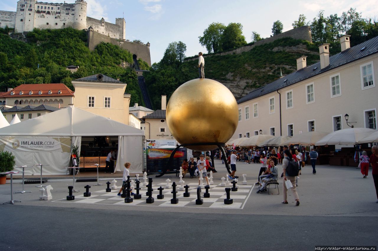 Памятник кондитеру Паулю Фюрсту и большая шахматная доска на площади Капительплац Зальцбург, Австрия
