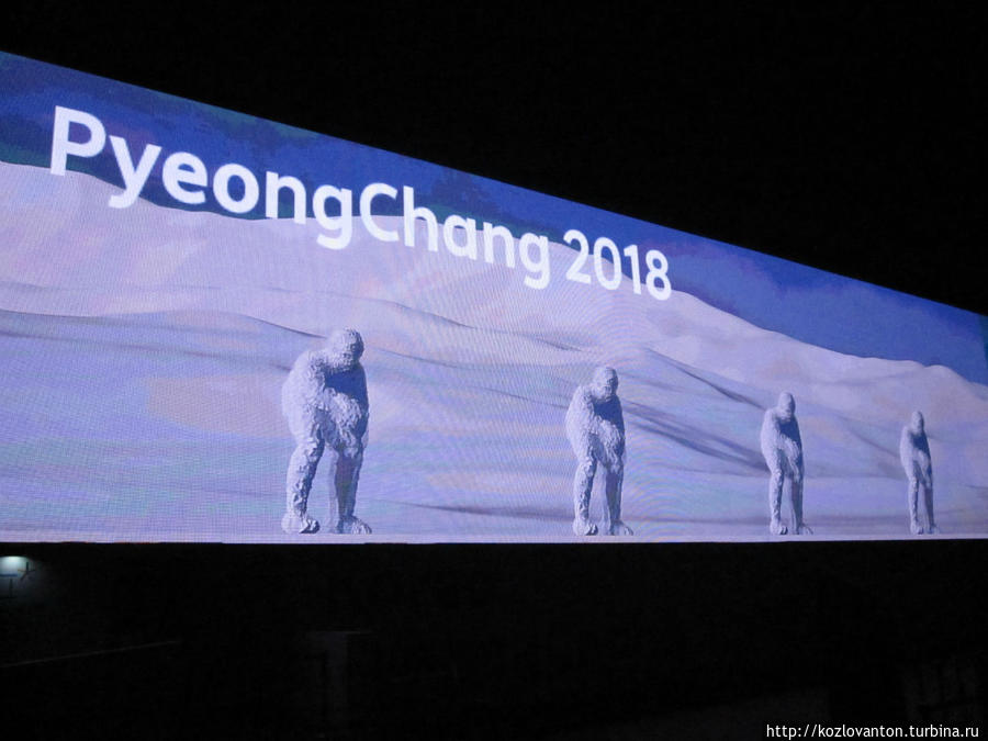 Электронный экран, рекламирующий игры — 2018 в Пхёнчане, протянулся во всю стену Дома гостеприимства республики Корея.