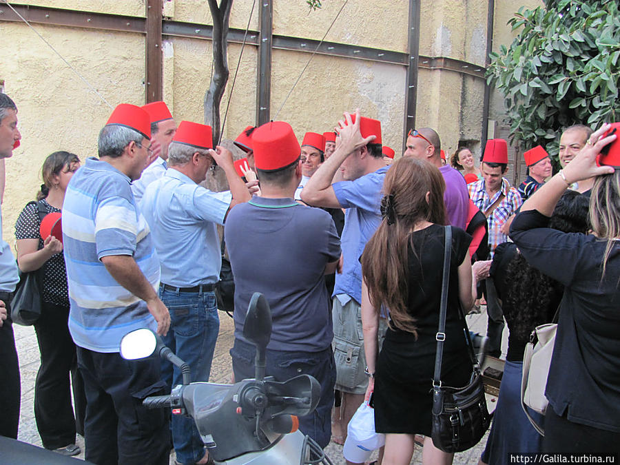 Марокканские туристы  получают шапочки от гида. Яффо, Израиль