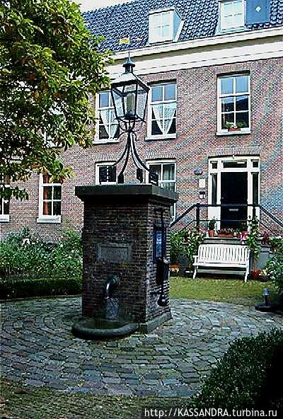 Внутренний дворик Brienenhofje. В середине водяной насос с красивым фонарем. Амстердам, Нидерланды