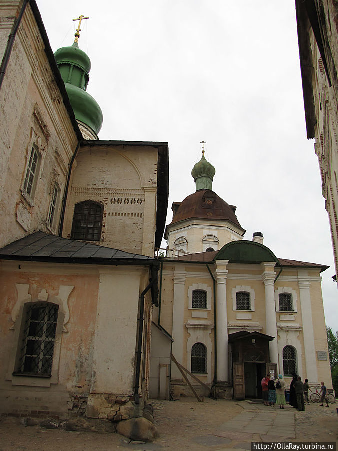 Успенский собор (1497) и церковь (вход)  преподобного Кирилла Белозерского (1585). Церковь преподобного Кирилла Белозерского — это небольшая церковь-придел примыкающая с запада к Успенскому собору Кирилло-Белозерского монастыря. Ранняя церковь 1585 года была копией церкви равноапостольного великого князя Владимира. Однако в XVIII веке за ветхостью церковь была разобрана и на её месте построена новая в стиле барокко. Она, безусловно, является самым чужеродным элементом всего монастыря. Действующая церковь, открыта для посещения.