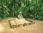 Скульптура правителя, сидящего со скрещенными ногами.
