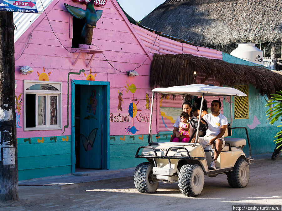 Большинство местных катаются по песчаным дорожкам острова на машинках для гольфа мимо пестро разукрашенных домиков, хоть расстояния тут и небольшие. Остров Холбос, Мексика