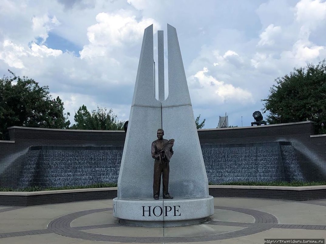 Hope-plaza на входе в парк, где сразу же видна скульптура Надежда — белый директор Красного креста держит новорожденного чёрного младенца