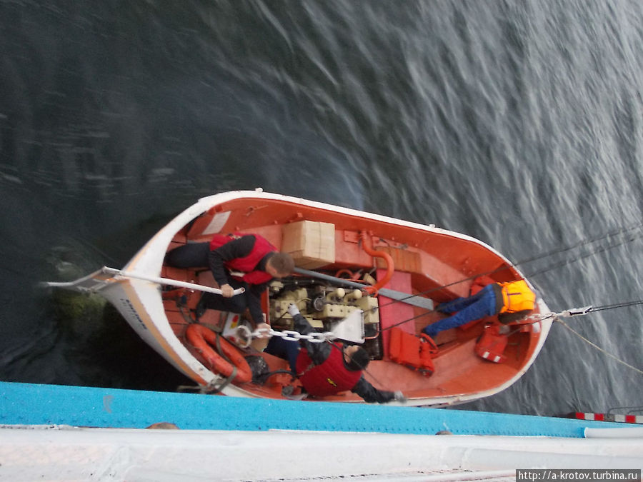 на маленьких пристанях спускается лодка-шлюпка с судна, высаживают людей так Туруханск, Россия