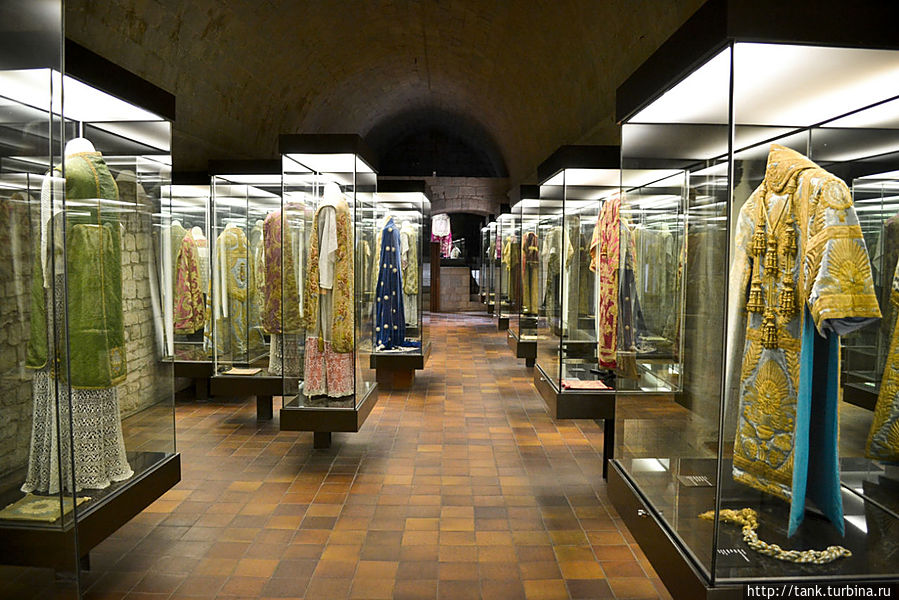 На верху, над одной из галерей, куда ведет узкая каменная лестница, в большом зале, собраны наряды епископов и других служителей веры.