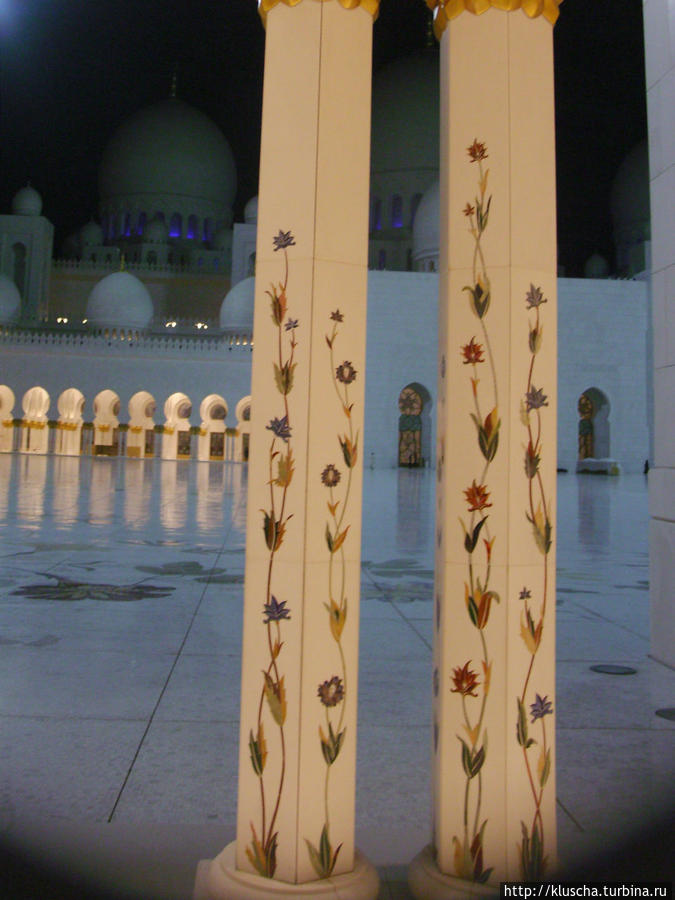 Искусно украшенные цветными лианами камней колонны подчеркивают их белизну. Дубай, ОАЭ