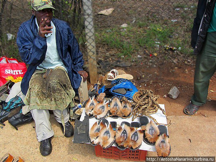 Сапожник. Продает традиционные тапочки, украшенные мехом антилопы импалы. Манзини, Свазиленд