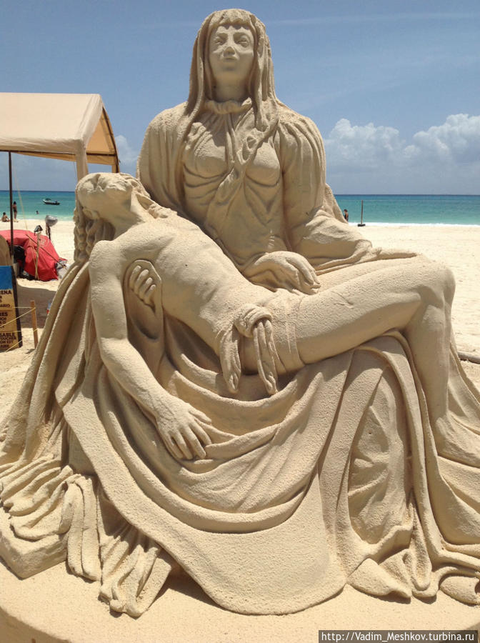 Песчаная скульптура (Пьета Микеланджело) на пляже Плайя Фундадорес в Плайя дель Кармен Плая-дель-Кармен, Мексика