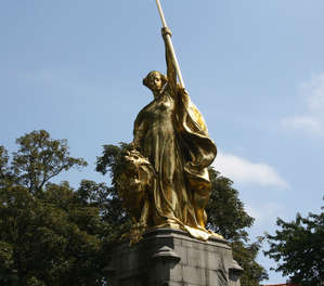 Позолоченная бронзовая фигура Магды Фландрской, которая пытается сдержать Льва, — центральная часть Памятника Золотым шпорам