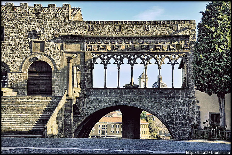 Дворец выстроен в романском стиле, лоджия же имеет ярко выраженный готический облик. Лоджия покоится на большой арке, в центре которой расположена восьмигранная колонна, внутри нее находится цистерна с водой, питающая фонтан в лоджии. Витербо, Италия