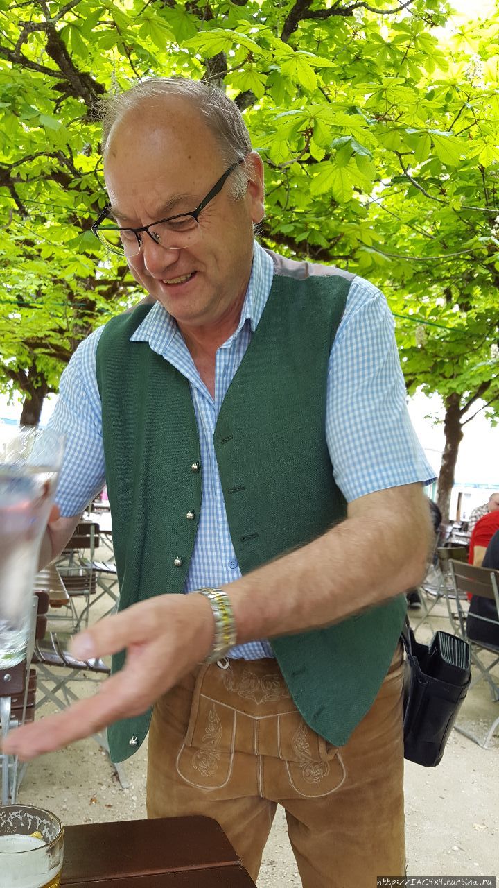 Официант в ледерхозе (кожаные шорты — основная деталь мужского тирольско-баварского костюма) Кёнигсзее, Германия