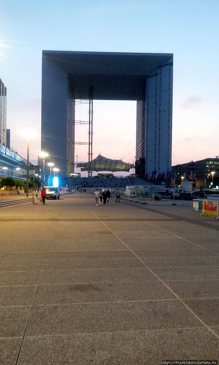 Большая арка, в боковинах которой расположены офисы. Вертикальная линия ближе к левому боку — шахта лифта на верхнюю обзорную площадку. Париж, Франция
