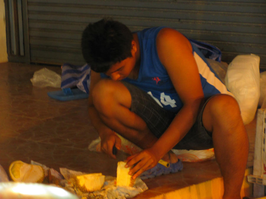 продавец разделывает дуриан подальше от прилавка Карон, Таиланд