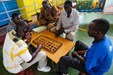 Игра в игисоро. Эта игра похожа внешне на нарды, но правила совершенно другие. Игисоро очень популярно в Руанде, и под разными именами известно по всей Африке.