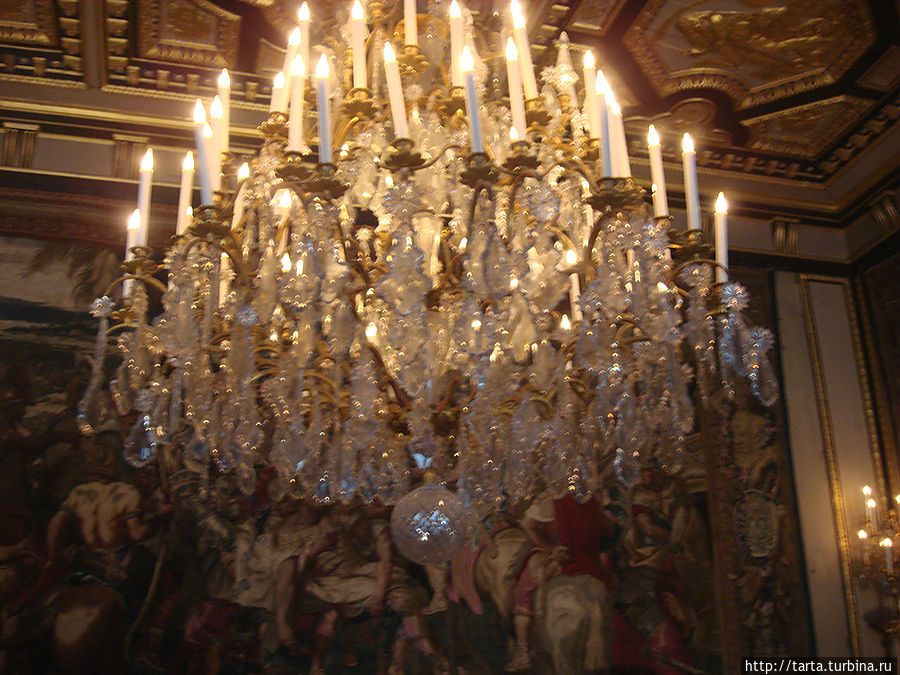 Низко висит люстра и много светильников, но в зале все равно мрачно