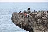 Рыбаки зависли на выдающейся в море скале.