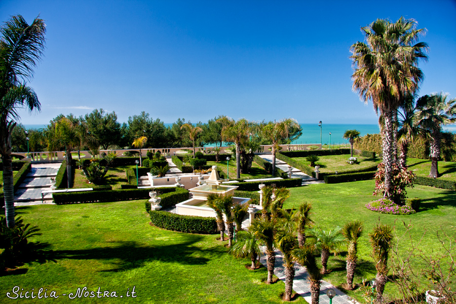 Недалеко от пляжа расположен ухоженный сад с пальмами и фонтаном. Сицилия, Италия