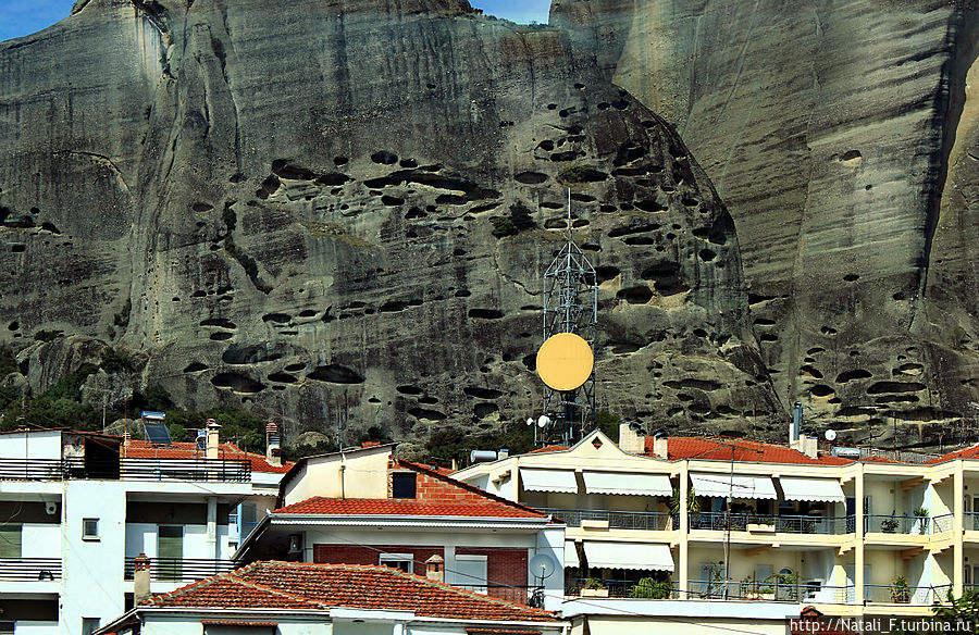 Скалы прям-таки нависают над домами Фессалия, Греция