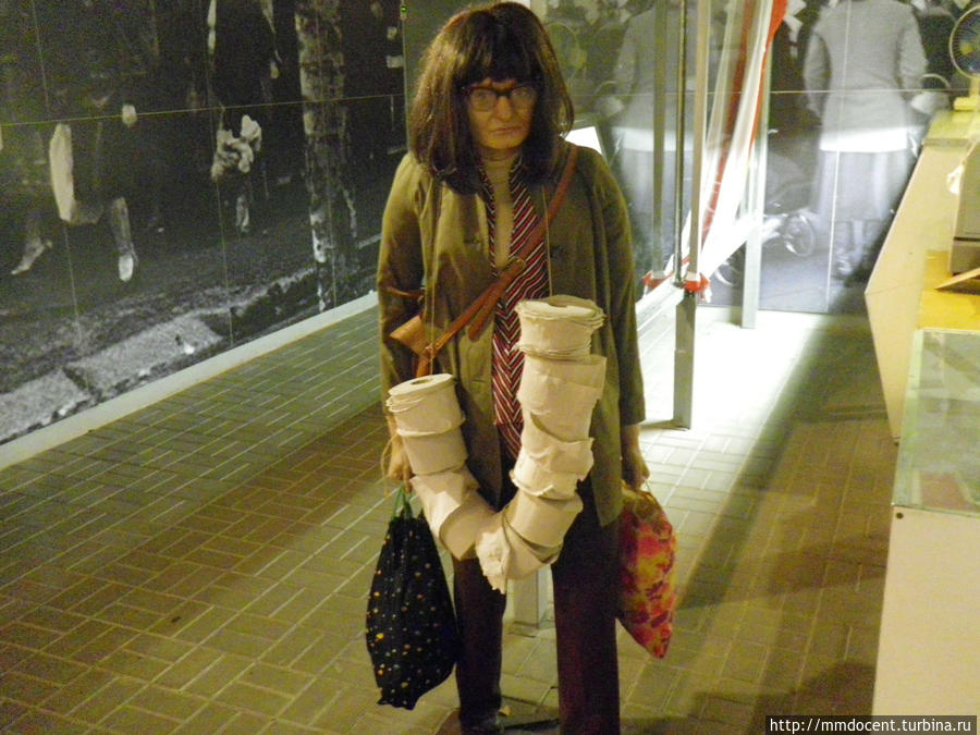 Фигура покупательницы, увешанной дефицитной туалетной бумагой. Гданьск, Польша