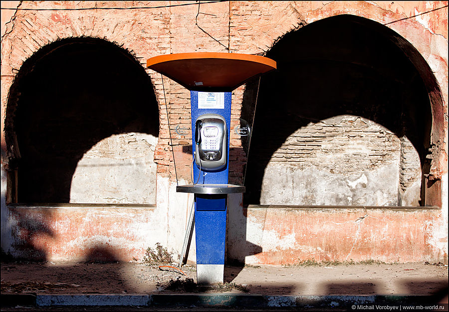 Новый телефонный таксофон, на фоне старых стен медины Тарудан, Марокко