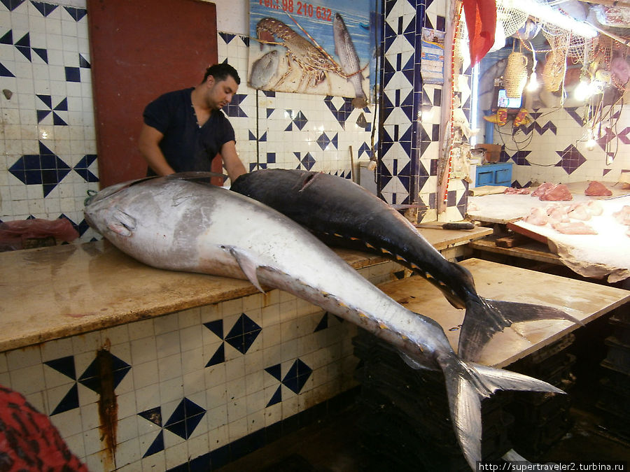 Рыбная часть рынка в Медине, продавец разделывает тунца