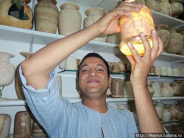 Свет выключен.В руках  у продавца изделие из лунного камня. Луксор, Египет