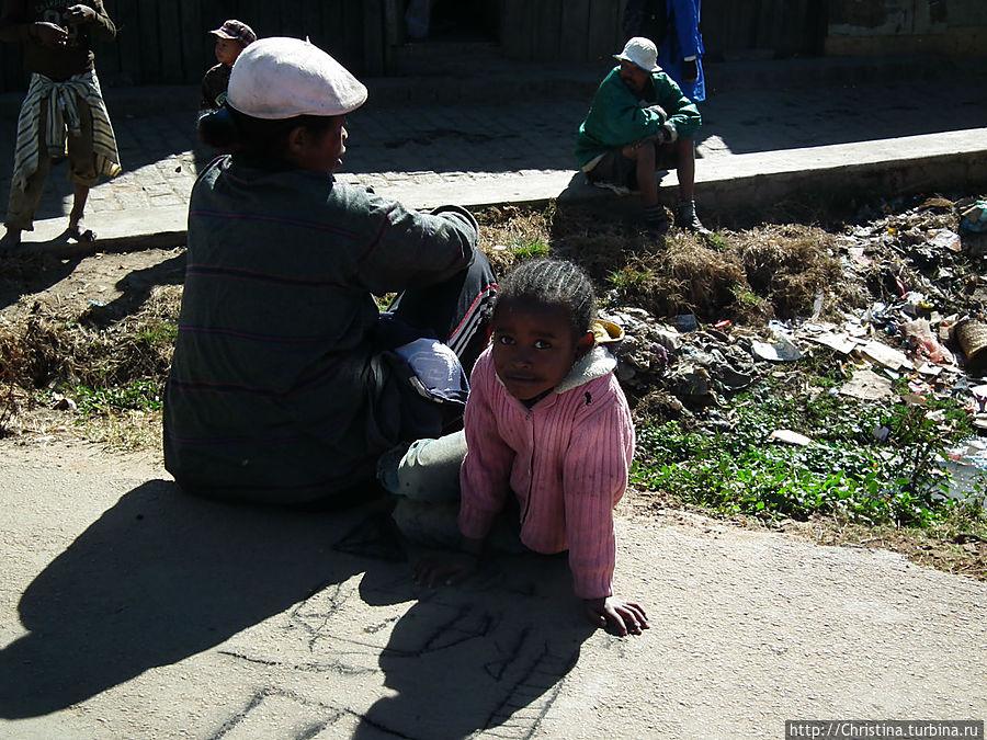 Дети, люди, нищие, отдыхающие и просто кто-угодно еще — все сидят на тротуарах и на обочине дороги. Антананариву, Мадагаскар